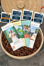 A selection of four award-winning chocolate bars presented in a basket, each with a label displaying the winning place and brand name.