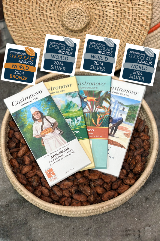 A selection of four award-winning chocolate bars presented in a basket, each with a label displaying the winning place and brand name.