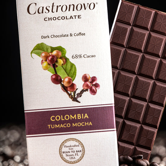 A chocolate bar with dark chocolate and coffee beans, packaging indicates it is 68% cocoa and from Colombia.