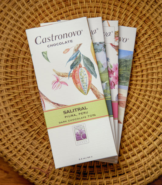Collection of Castronovo chocolate bars on tan woven background with Salitral 70 percent dark chocolate on the top of the stack