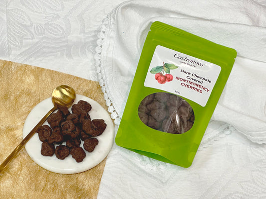 Castronovo dark chocolate-covered Montmorency tart cherries in green packaging, with product displayed on plate to side
