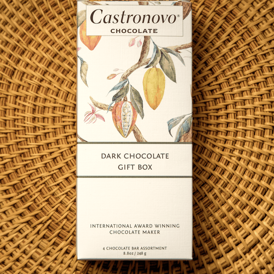 A packaged gift box of Castronovo dark chocolate bars with a floral design on the packaging, placed on a woven basket.