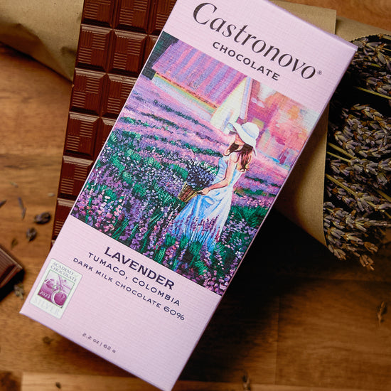 A chocolate bar packaging with an image of a woman in a field of lavender, alongside pieces of dark milk chocolate.