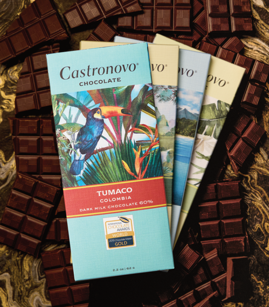 Four milk chocolate bars resting on top of each other with Tumaco Dark Milk at the top 